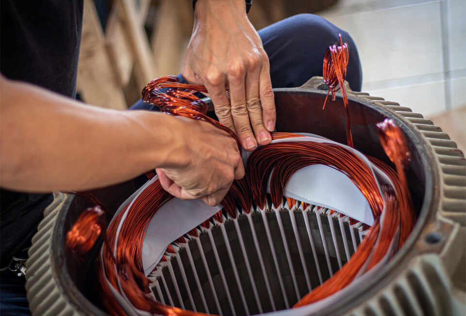 person rewinding the stator of an electric motor