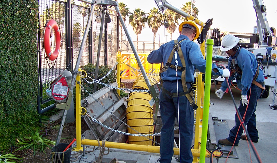 two maintenance workers at construction scene, involving underground utility work