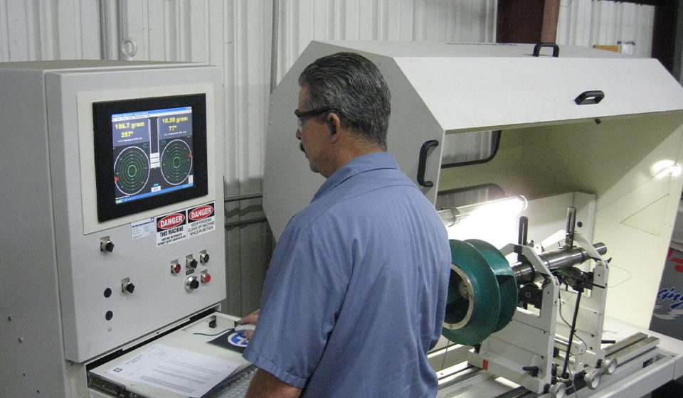 staff on the dynamic balancing machine, used in an industrial setting to measure and correct imbalance in rotating parts